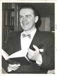 Photograph of Thomas F. Lambert posed with a book and pipe, circa 1950s by Unknown