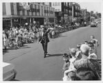 John Joseph Moakley walking and waving to crowd at a parade in South Boston (MA), 1960s by unknown