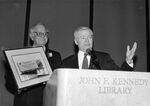 William Bulger speaking into microphone behind podium at "Irishman of the Year" event honoring Congressman John Joseph Moakley at John F. Kennedy Library by unknown